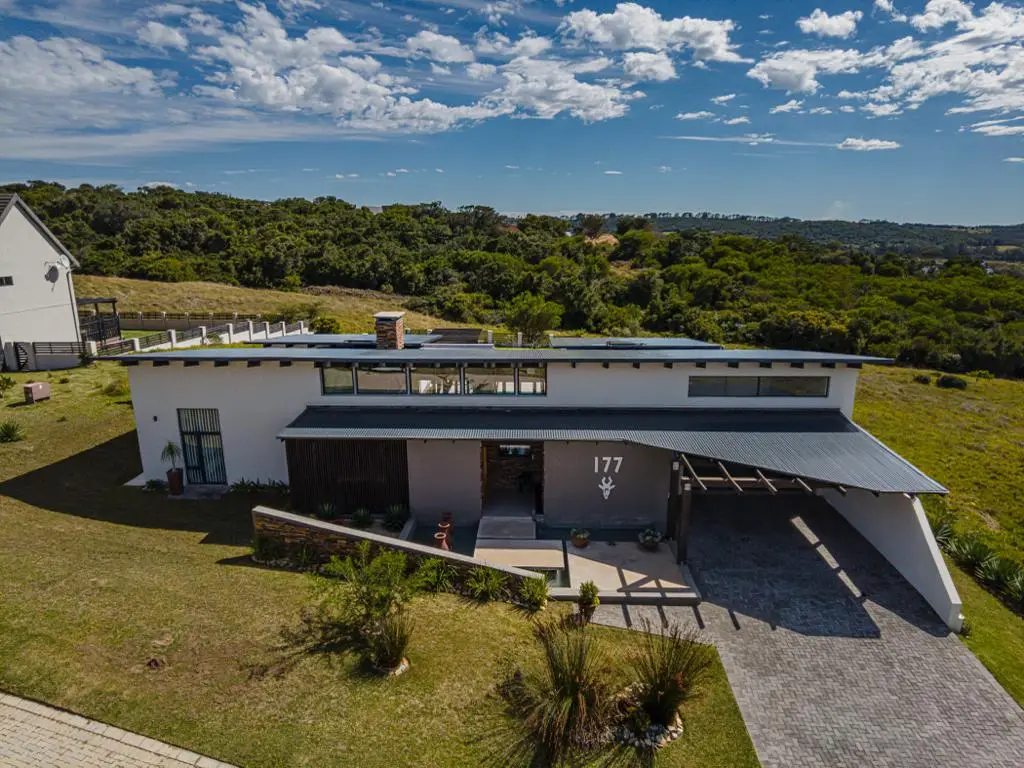 New home construction in Knysna by RVR Building Projects — exposed-truss living area, stone entrance and pool